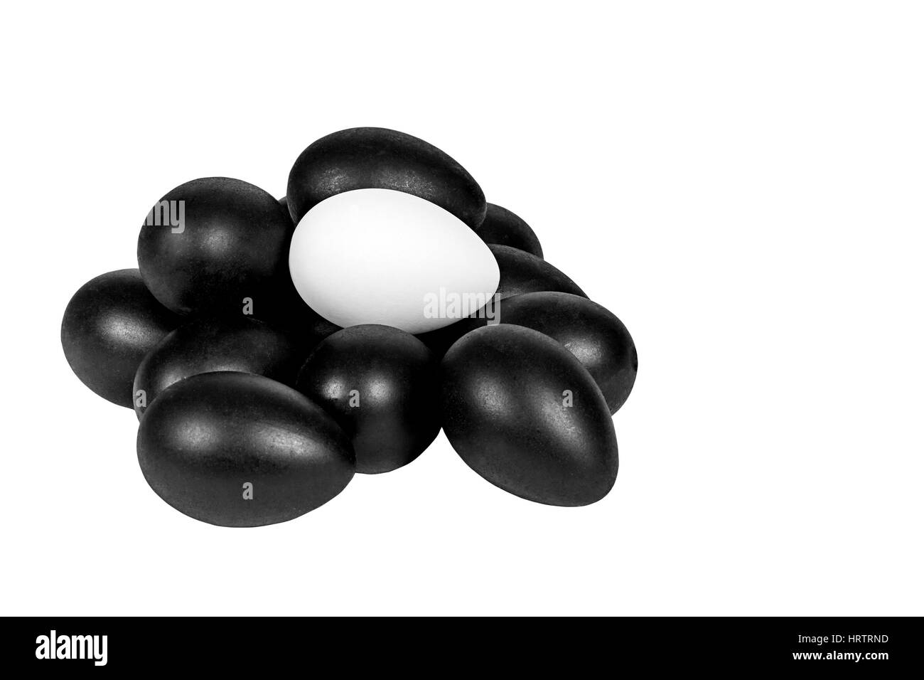 Haufen von schwarzen Eiern mit ein weißes Ei an der Spitze isoliert auf weiss Stockfoto