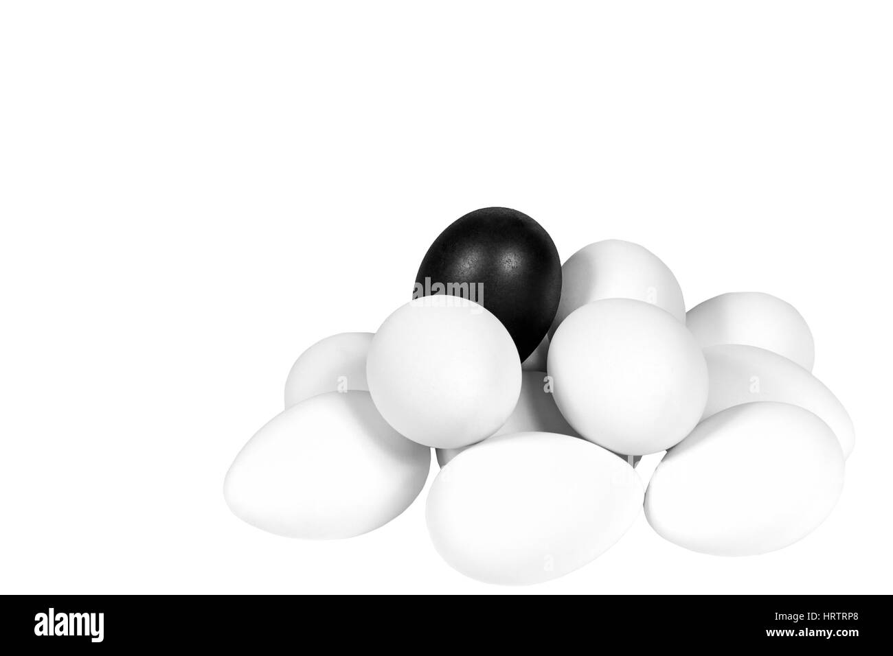 Weißen Eiern im Stapel mit einem schwarzen Ei an der Spitze Stockfoto