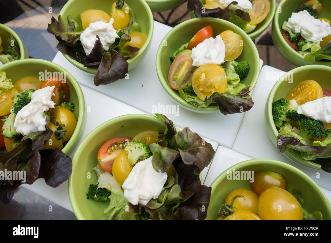 Nahaufnahme von grüner Salat Conisting von Cherry-Tomate, Brokkoli, Salat und Käse in kleinen Schalen serviert Stockfoto