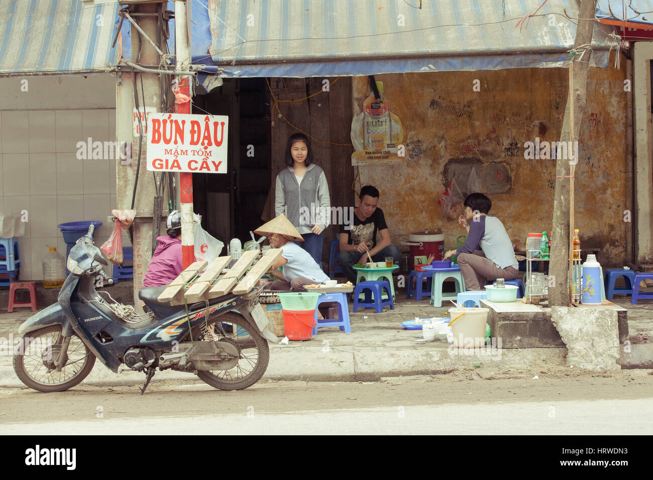 Hanoi, Vietnam - 2. März 2014: Einheimische Essen, sitzen auf Plastikstühlen an das traditionelle Straßencafé. Stockfoto