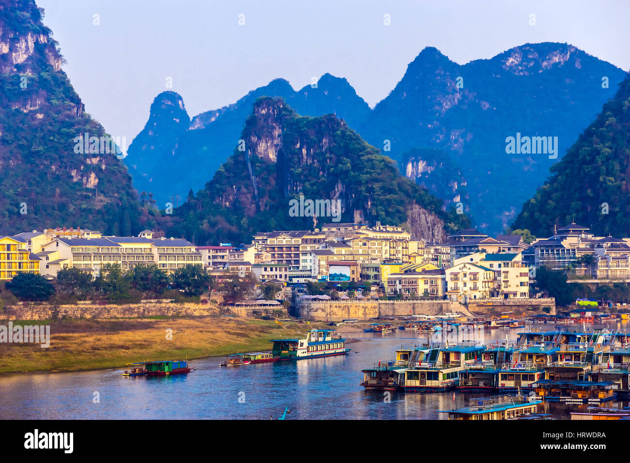 Blick auf Resort Stadt Guilin in Zentralchina mit vielen weißen Gebäuden Boot Peer Fluss und Karstberge auf Hintergrund Stockfoto