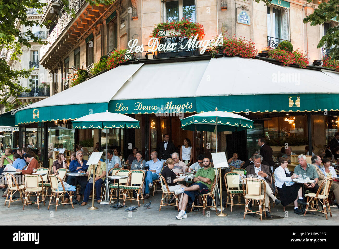 Speisen im Freien, Blick auf das berühmte Les Deux Magots Café, Gäste sitzen auf Bürgersteig-Tischen, Paris, Frankreich. Stockfoto
