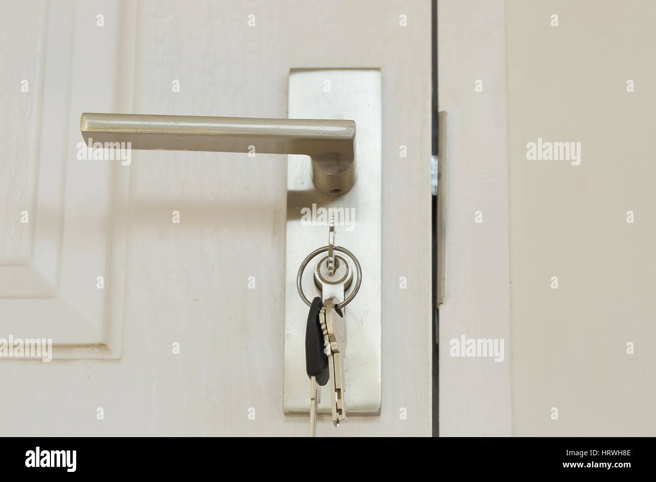 Schlüssel stecken Sie und halten in metallischen Knopf auf weiße Tür horizontal, Architektur von Schlosser Stockfoto