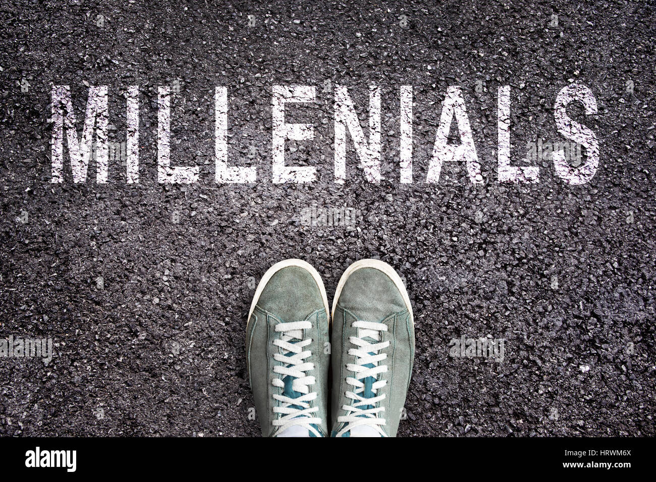 Text Millennials geschrieben auf Asphalt mit Schuhen Stockfoto