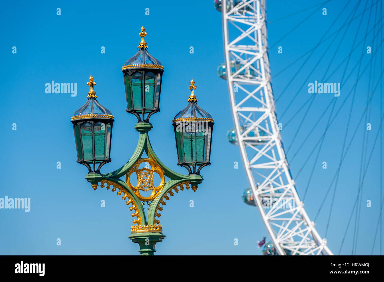 Das London Eye von Westminster Bridge mit der Straßenlaterne auf der Brücke im Vordergrund. Stockfoto