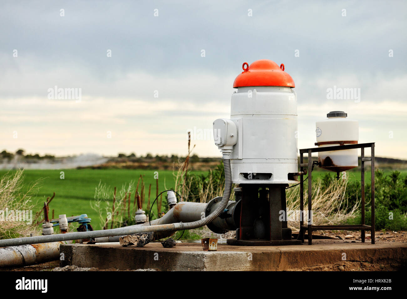 Das Pumpwerk Wasser gut vom Boden gepumpt, wobei an Bewässerung Sprinkler in Bauernhof-Feldern verteilt. Stockfoto