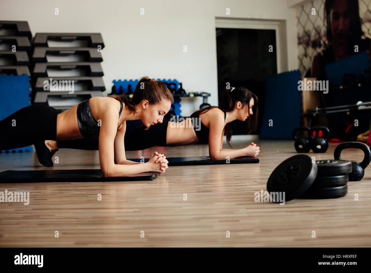 Fitness Mädchen tun Plank Yoga Übungen im Fitness-Studio. Plank Challenge trainieren. Stockfoto