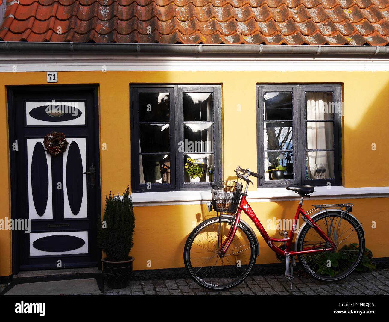 Res Fahrrad lehnt sich an die gelbe Wand eines süßen kleinen Hauses in Aeroskobing auf der dänischen Insel Aero im Südlichen Funen Archipel Stockfoto