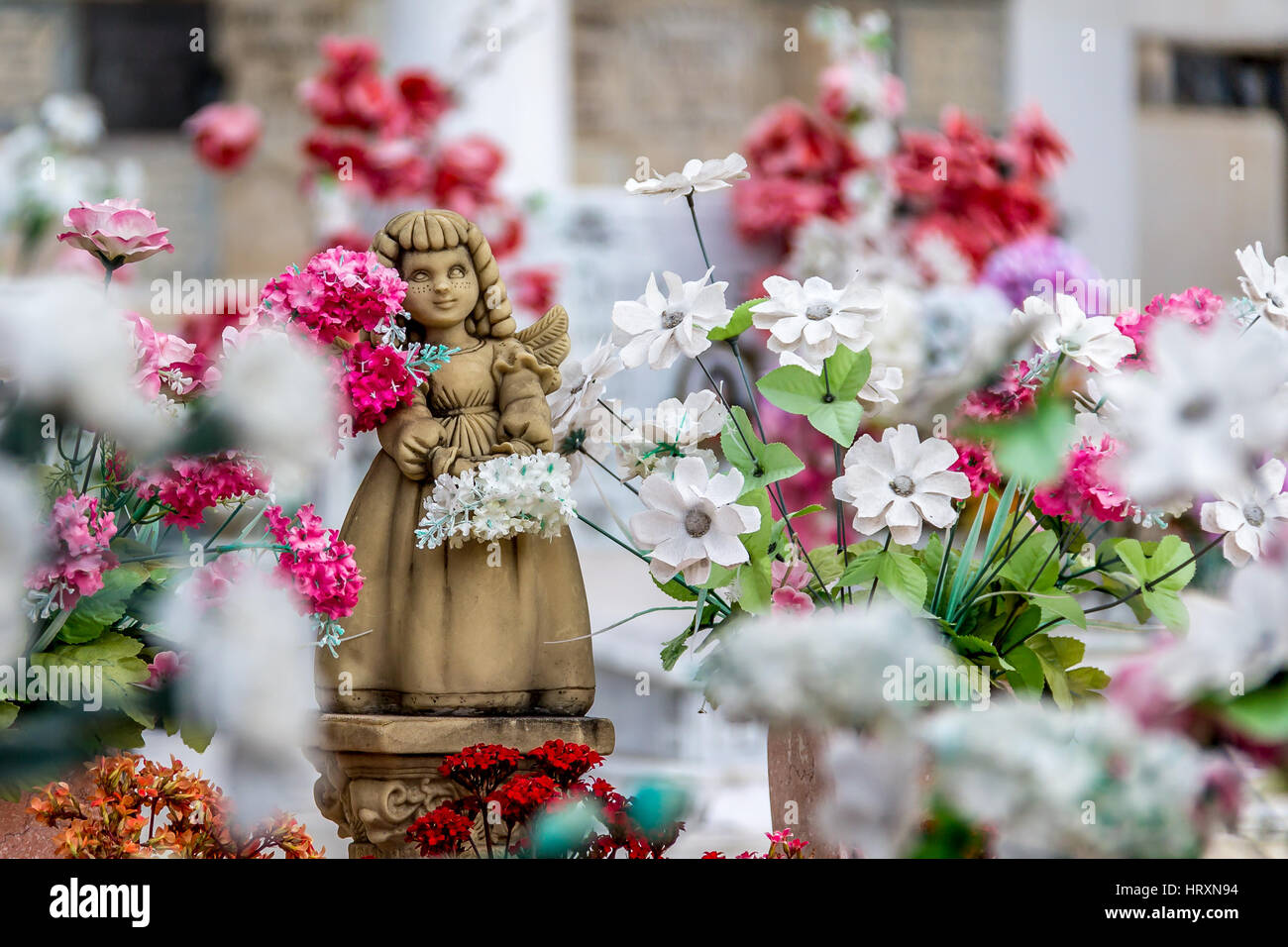 Niedliche Engel Mädchen Statue und Blumen Stockfoto