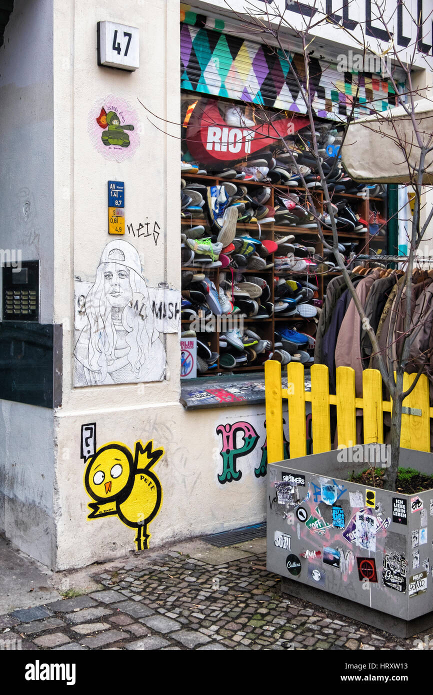 Berlin, Prenzlauer Berg. Streetart von El Bocho außerhalb Second-Hand Bekleidungsgeschäft. Kunstwerke - Little Lucy in einem Tank, Pete den gelben Vogel Stockfoto
