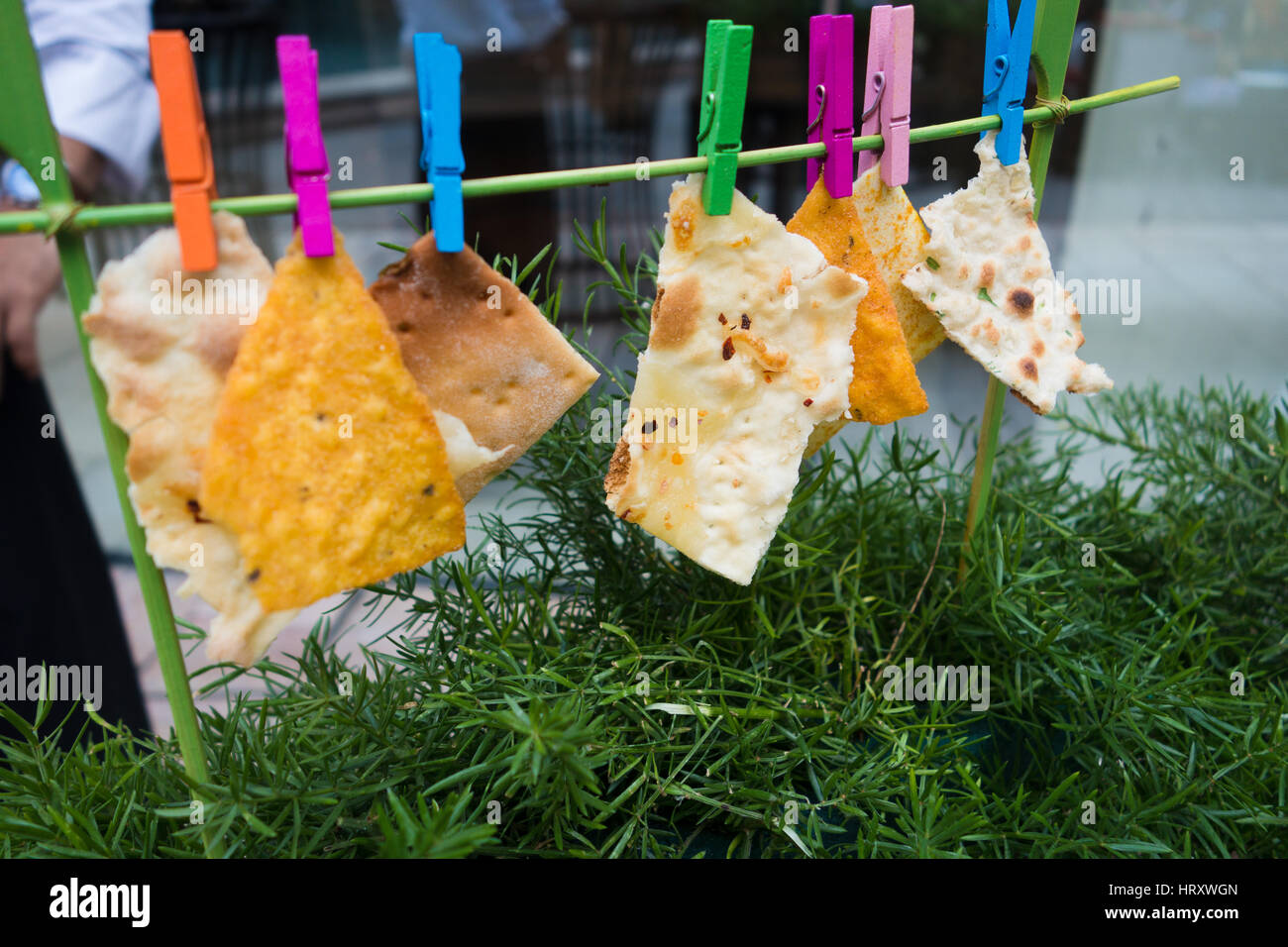 Kreative foodstyling von Nachos und Fladenbrot hing mit farbigen Clips Stockfoto