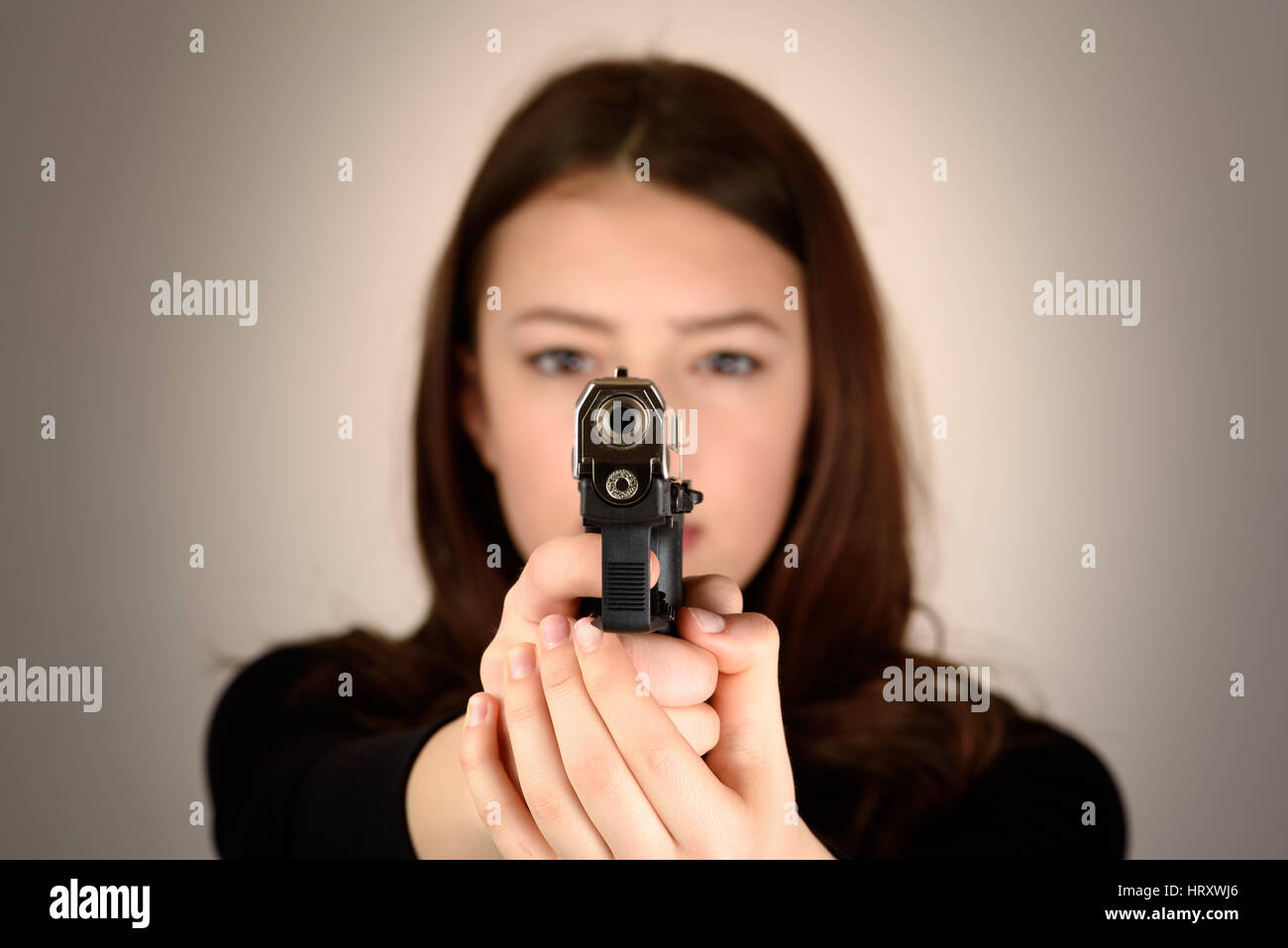 Junge Frau mit einer Pistole in die Kamera hautnah Stockfoto