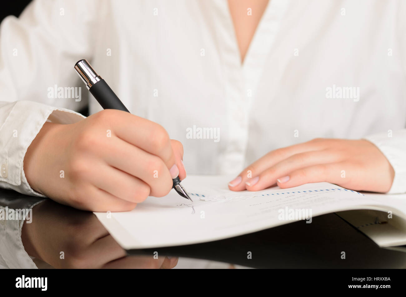 Nahaufnahme von Frau, die ein Dokument oder einen Vertrag zu unterzeichnen Stockfoto