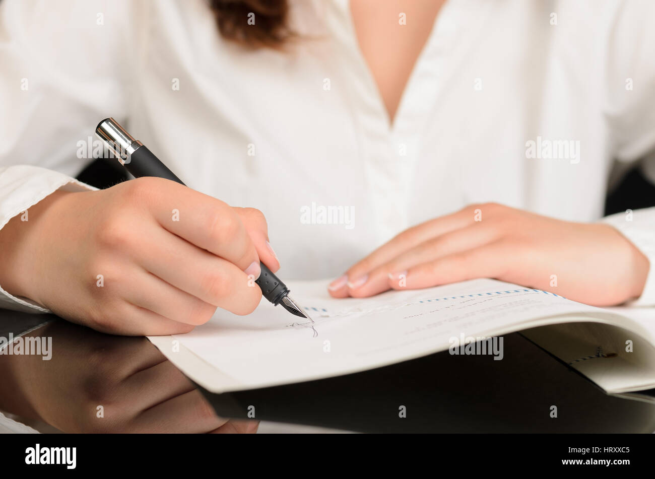 Nahaufnahme von Frau, die ein Dokument oder einen Vertrag zu unterzeichnen Stockfoto