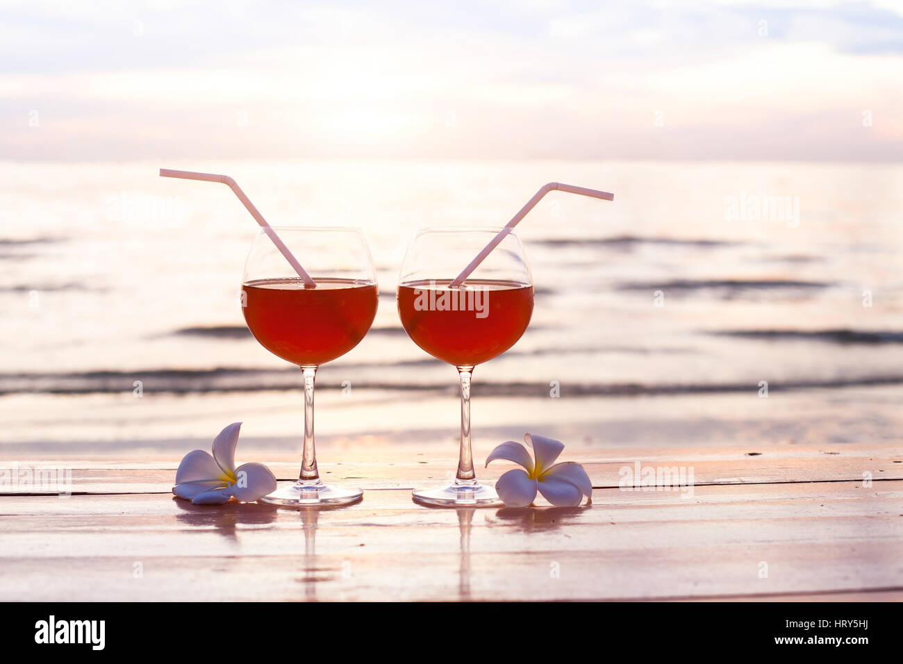 Cocktails am Strand bei Sonnenuntergang, zwei Gläser, Romantikurlaub Hintergrund Stockfoto