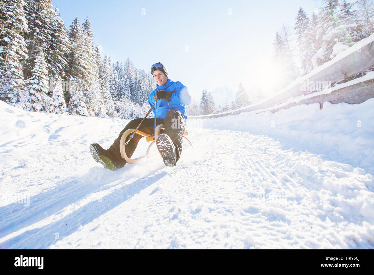 Schlitten, Winter Schnee Urlaubsaktivität, junger Mann Spaß Rodeln Stockfoto