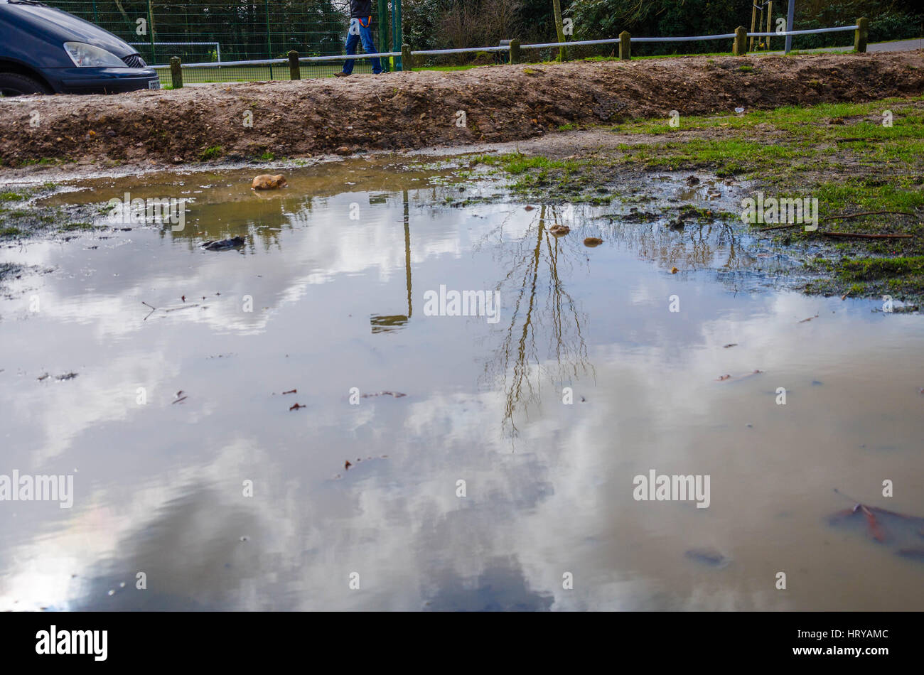 Eine schlammige Pfütze im Prospect Park in Reading in dem Himmel und Umgebung als Spiegelbild gesehen werden können. Stockfoto