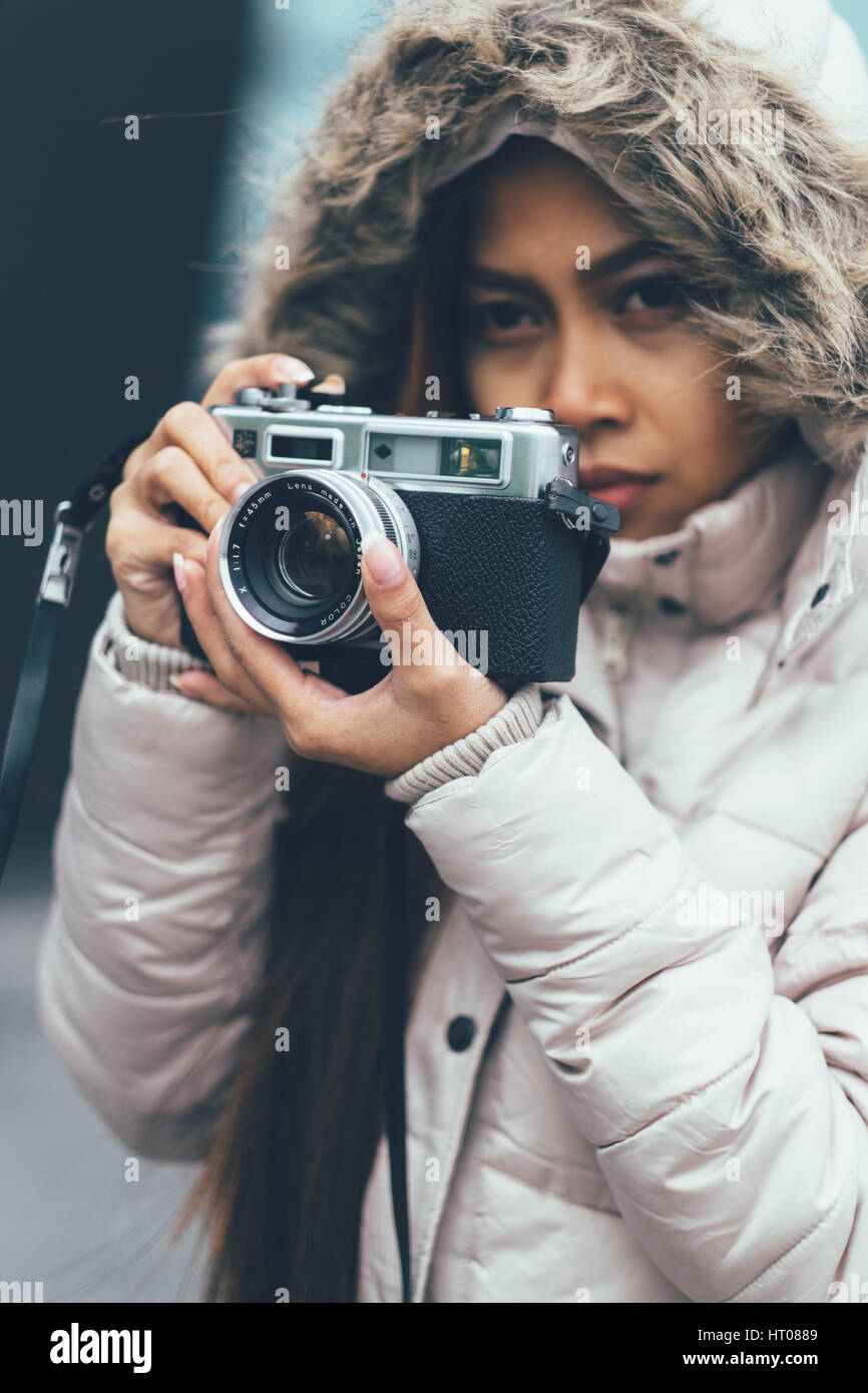 Schöne Mädchen fotografieren mit Retro-Kamera in der städtischen Umwelt, Stadt Stockfoto