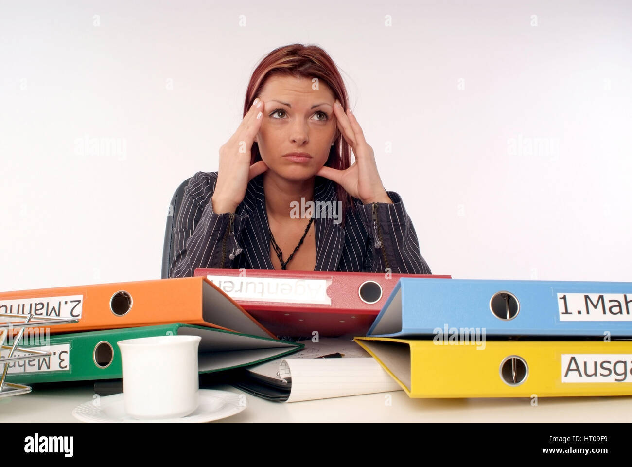 Gestresste, Ueberforderte Geschaeftsfrau bin Schreibtisch - gestresst, überfordert Geschäftsfrau im Büro Stockfoto