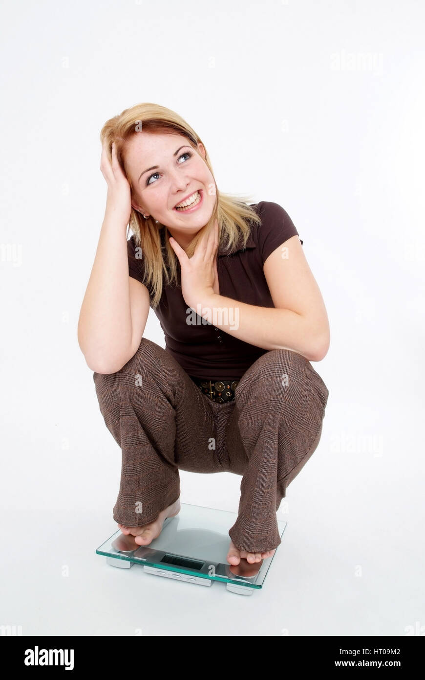 Froehliche Frau Auf Waage - glückliche Frau im Maßstab Stockfoto
