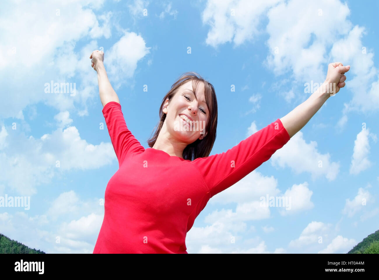 Glueckliche Frau Streckt Sich Unter Blauem Himmel - glückliche Frau vor einem blauen Himmel Stockfoto