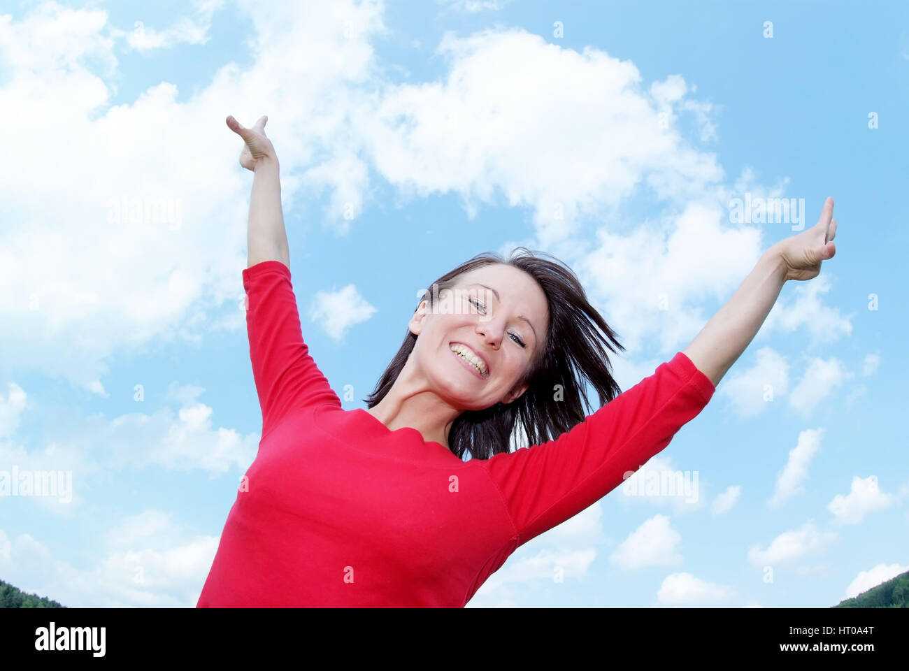 Glueckliche Frau Streckt Sich Unter Blauem Himmel - glückliche Frau vor einem blauen Himmel Stockfoto