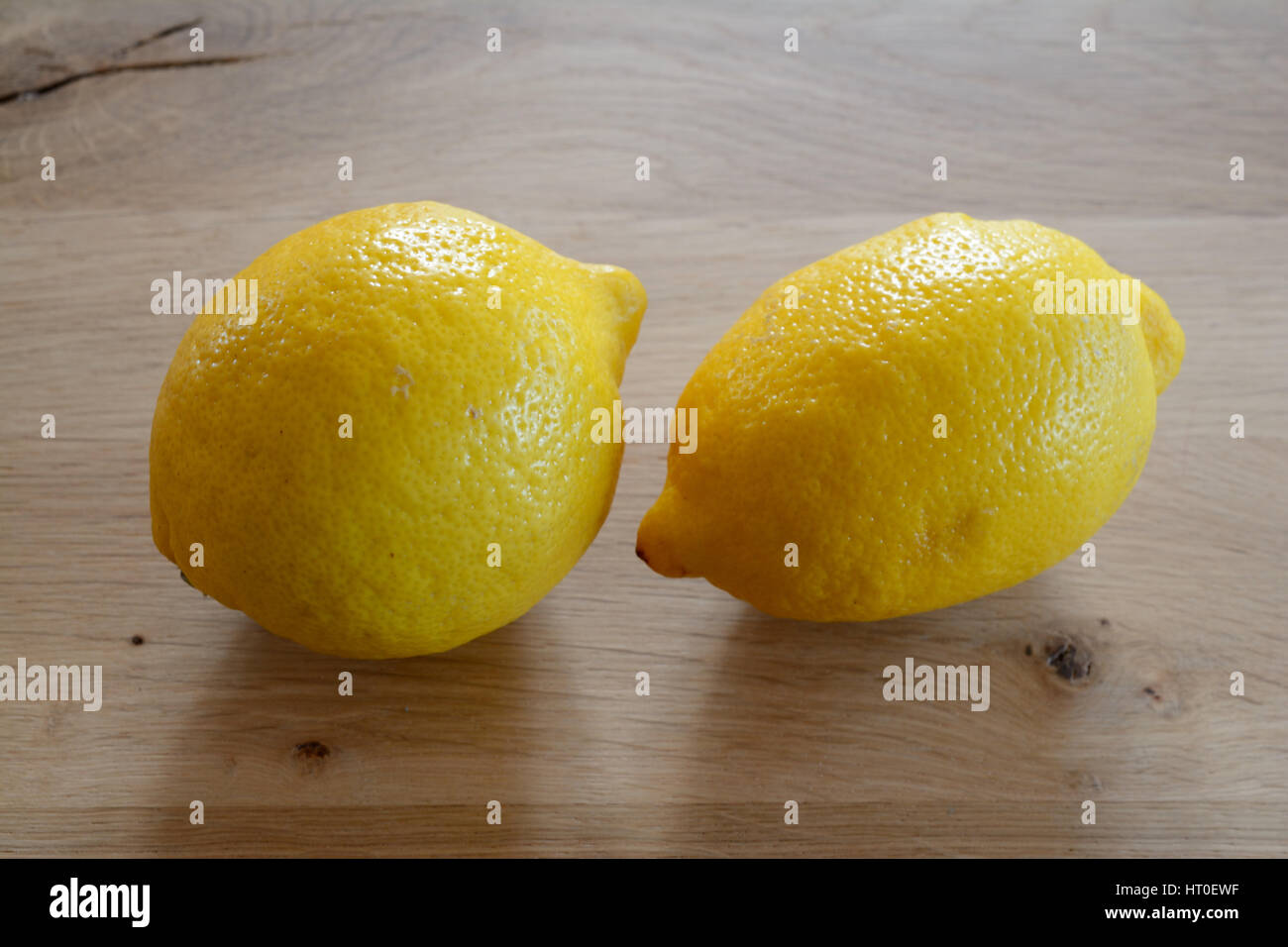 Zwei gelbe Zitronen auf hölzernen Tischplatte. Geringe Schärfentiefe. Stockfoto