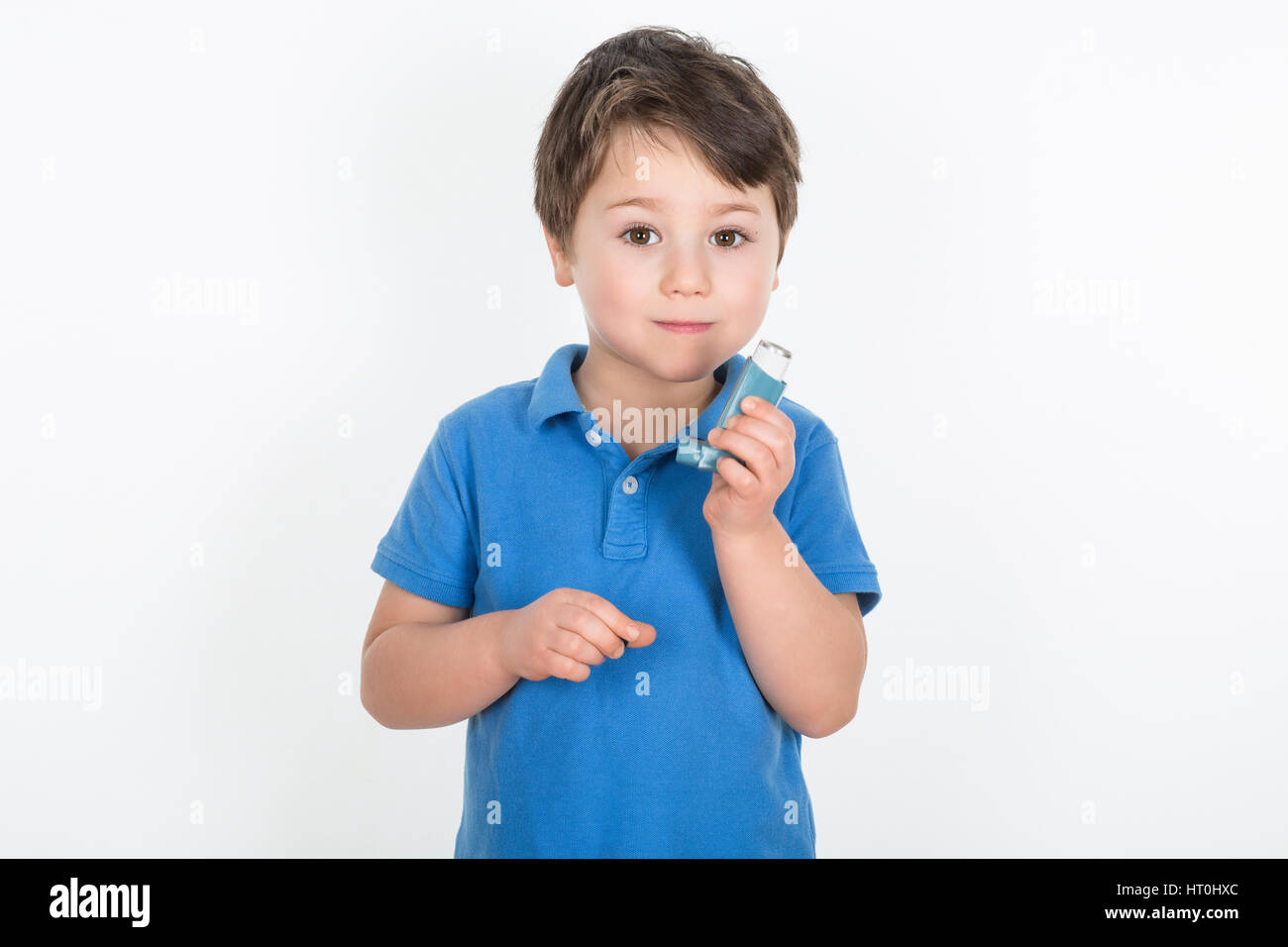Kleiner Junge mit Asthma hält einen dosiert-Dose-Inhalator "Puffer". Isoliert auf weißem Hintergrund. Stockfoto