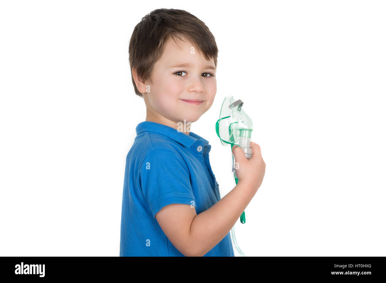 Kleiner Junge, Asthmatikers, hält in seiner Hand Gesichtsmaske aus Vernebler Inhalator Maschine und lächelnd. Isoliert auf weißem Hintergrund. Stockfoto