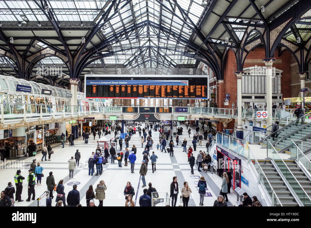 Passagiere warten für Züge und die Station Boards in der Londoner Liverpool Street Station ansehen Stockfoto