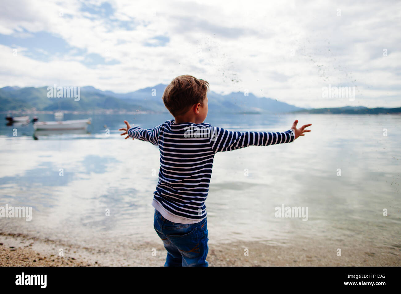 Junge werfen mit Steinen im Wasser Stockfoto