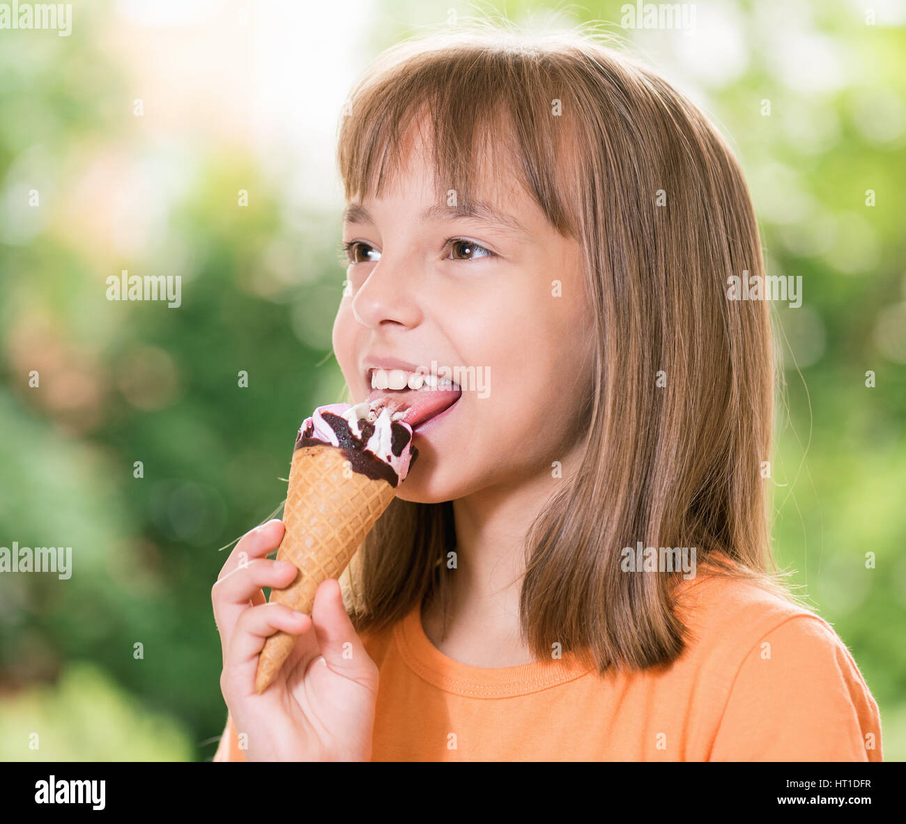 Outdoor Portrait von glücklichen Mädchen 10-11 Jahre alt mit Eiscreme-Kegel Stockfoto