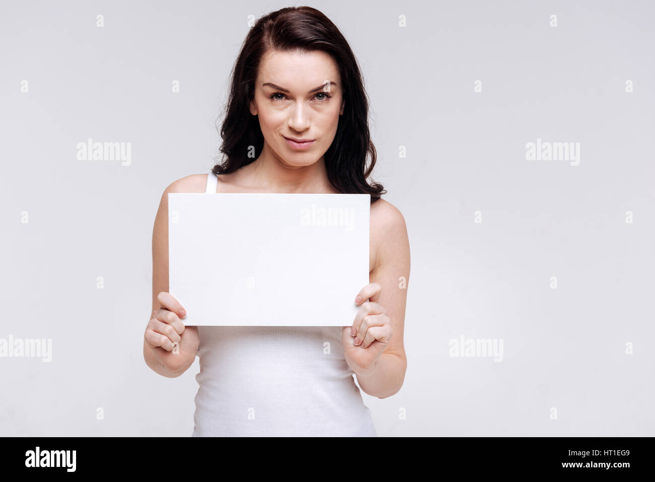 Nicht beeindruckt. Elegante moderne Frau posiert mit einem Stück Papier und zeigt erforderliche Emotionen während der Werbung Sozialgleichheit gewidmet Stockfoto