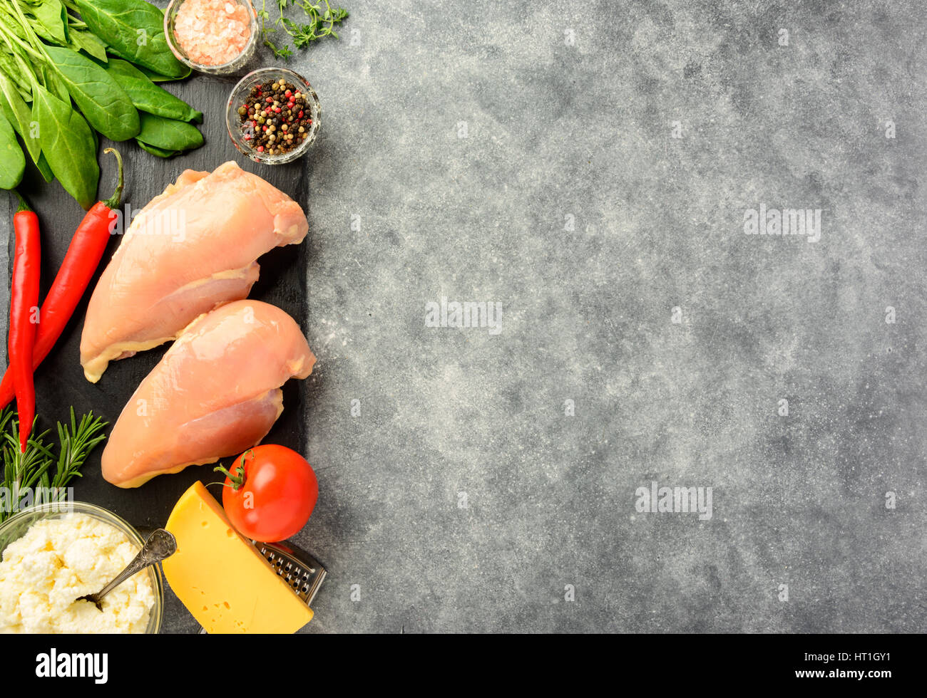 Bereit zum Kochen Hähnchenfilet mit Spinat und Käse auf einem dunklen Hintergrund. Ansicht von oben, Raum zu kopieren. Stockfoto