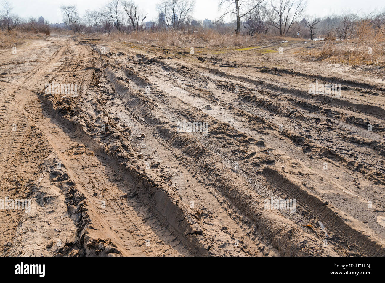 Tiefe Reifen Spuren auf der Straße von nassen, schlammigen Sand abgedeckt Stockfoto