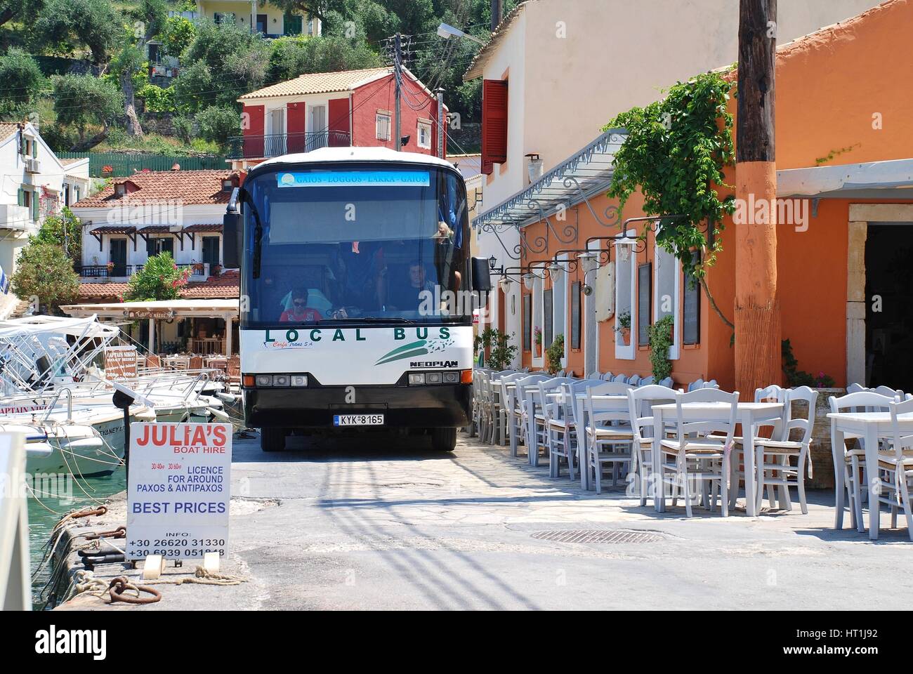 Der Insel-Bus fährt entlang der engen Hafen Straße in Loggos auf der griechischen Insel Paxos. Diners haben oft ihren sitzen zu lassen, durch verlassen. Stockfoto