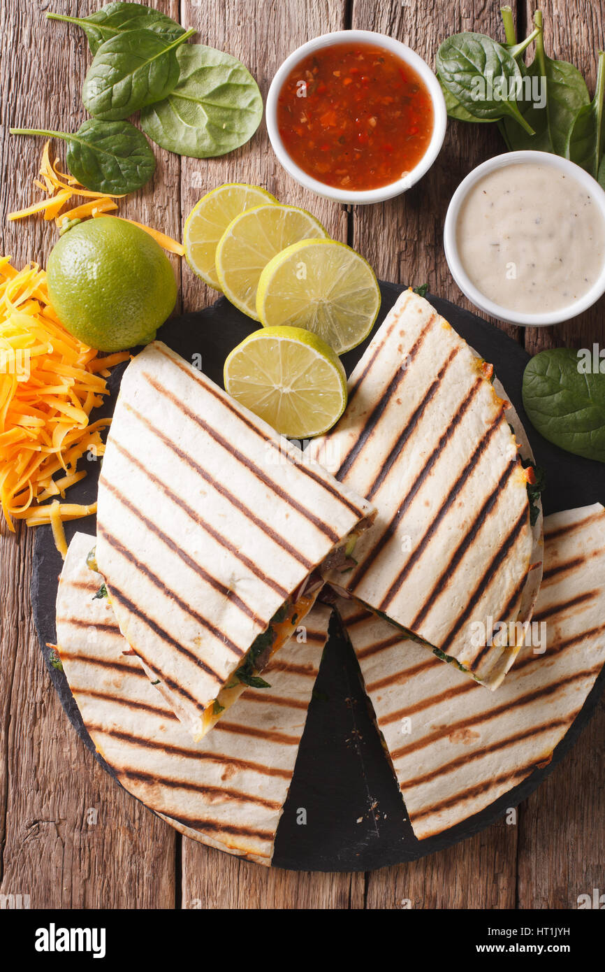 Gegrillte Quesadilla mit Rindfleisch, Spinat und Cheddar Käse Nahaufnahme auf dem Tisch. vertikale Ansicht von oben Stockfoto