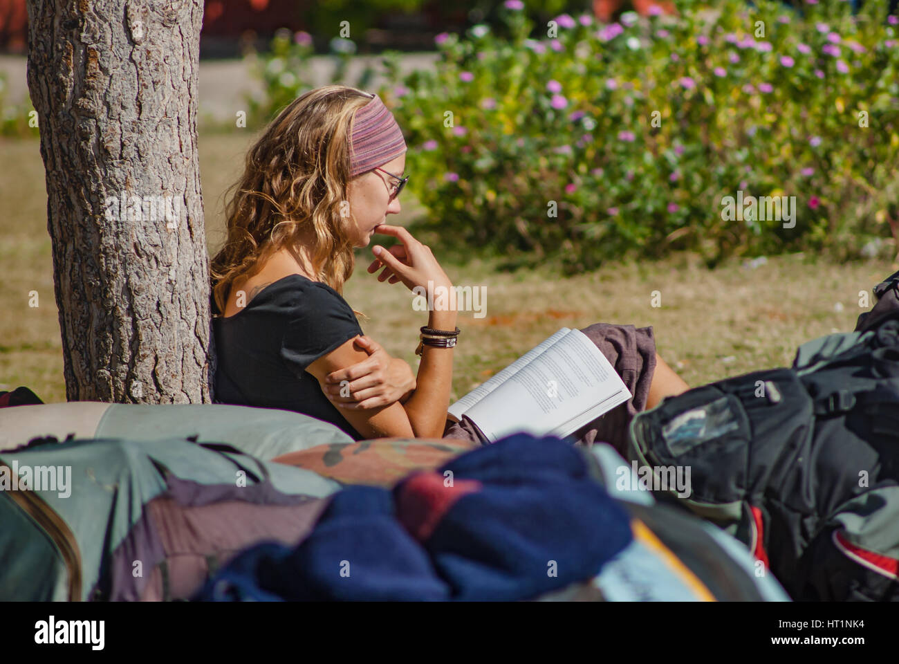 Mädchen-Lesebuch im Park im Sommer Mitte Tag Stockfoto