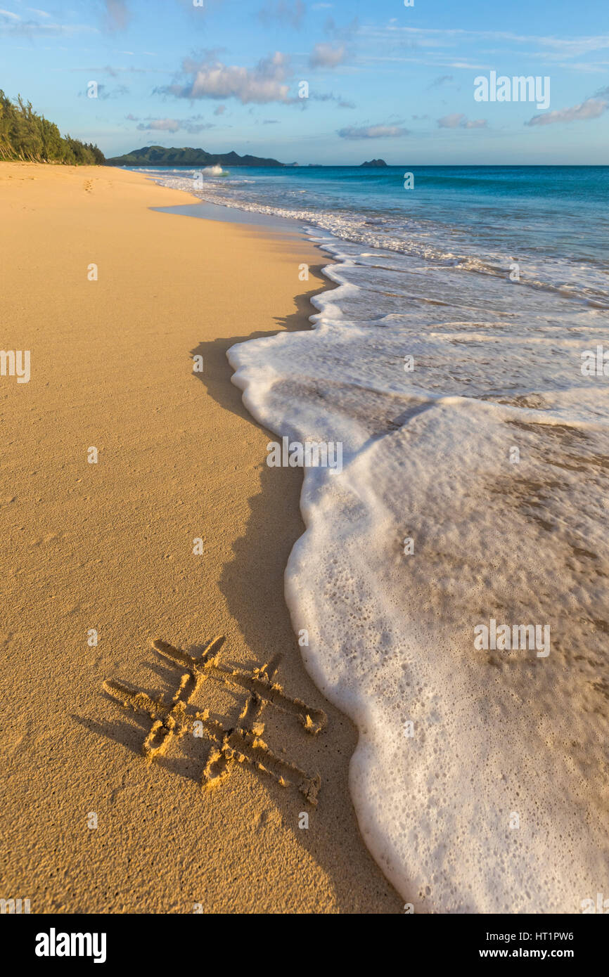 Ein Hashtag an einem Strand in den Sand gezeichnet. Stockfoto