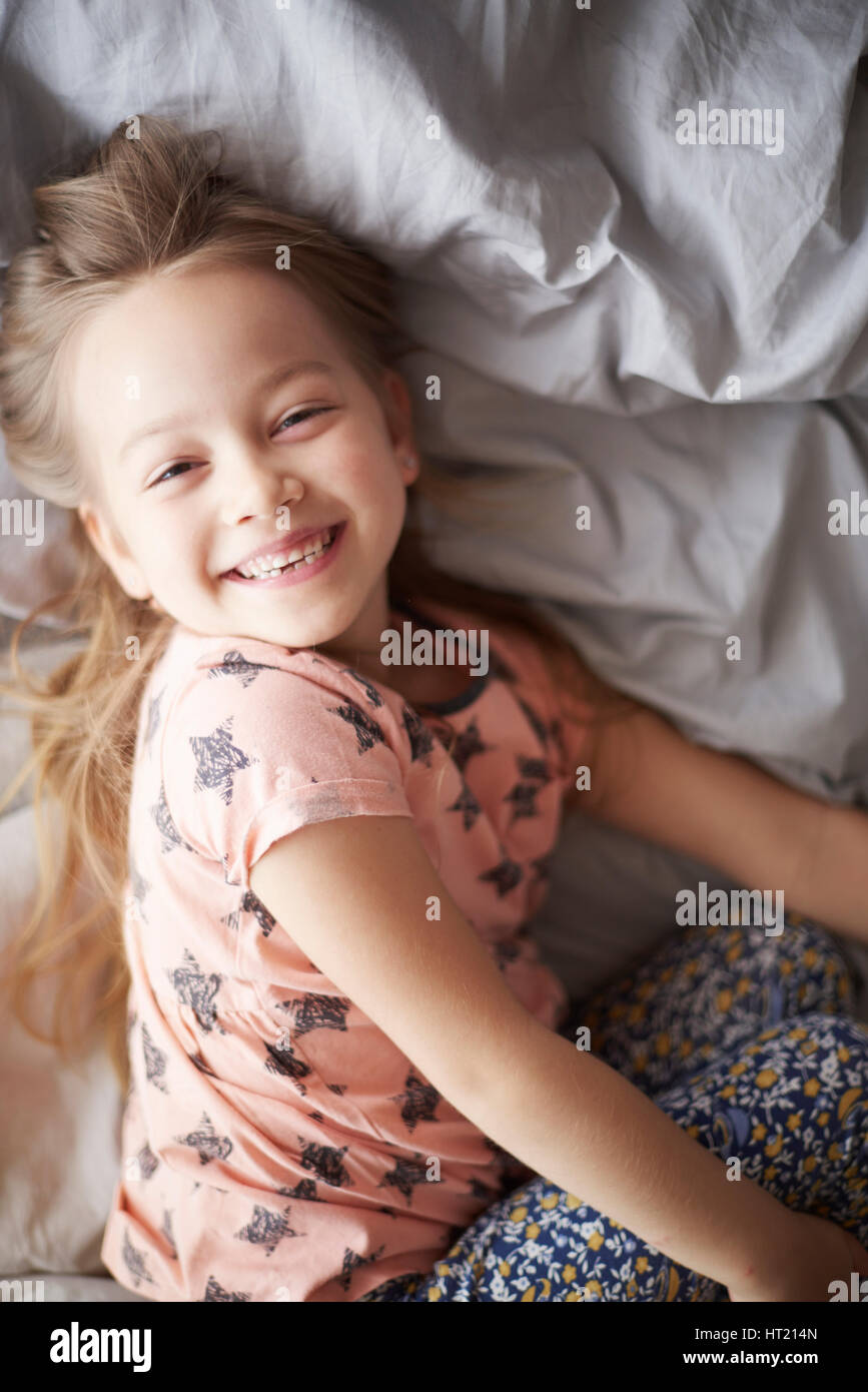 Glückliches Mädchen im Bett in den Morgen Stockfoto