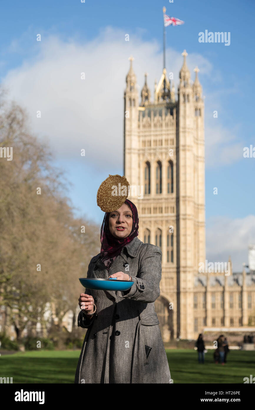 Ein Besucher dreht einen Pfannkuchen im 20. jährlichen parlamentarischen Pfannkuchen Rennen findet am Faschingsdienstag bei Victoria Tower Gardens außerhalb Houses of Parliament in London. Stockfoto