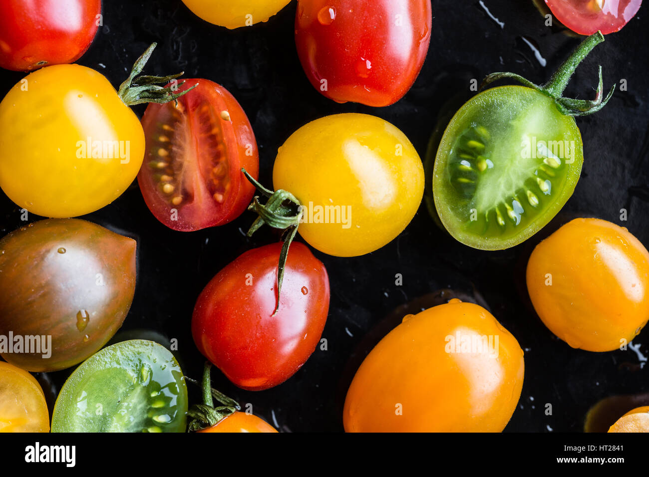 Mehrfarbige Tomaten auf schwarzem Hintergrund Stockfoto