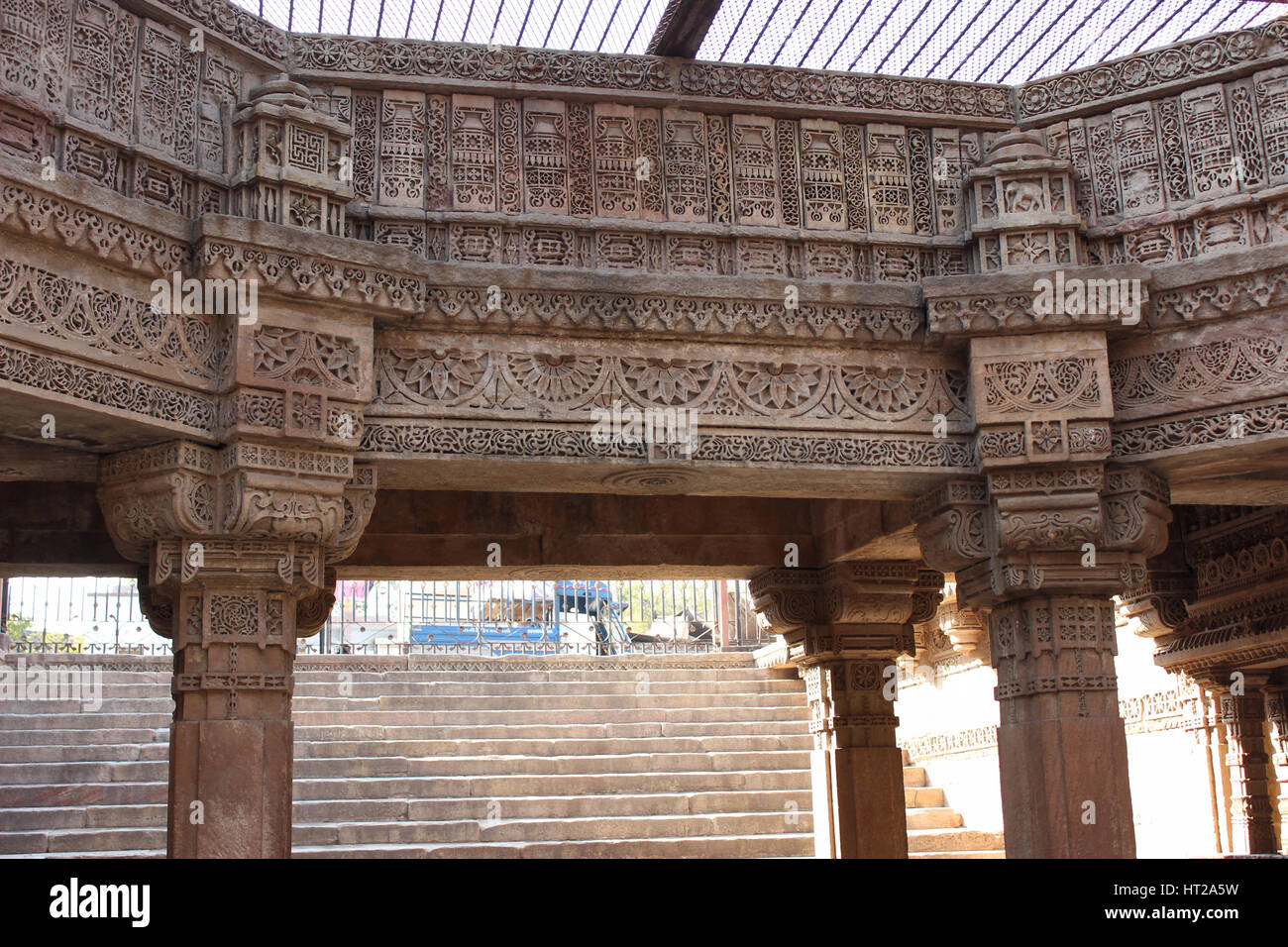 Komplizierte Muster geschnitzt auf den steinernen Tafeln eines achteckigen Innenhof-Struktur. Adalaj Stufenbrunnen, Ahmedabad, Gujarat, Indien Stockfoto