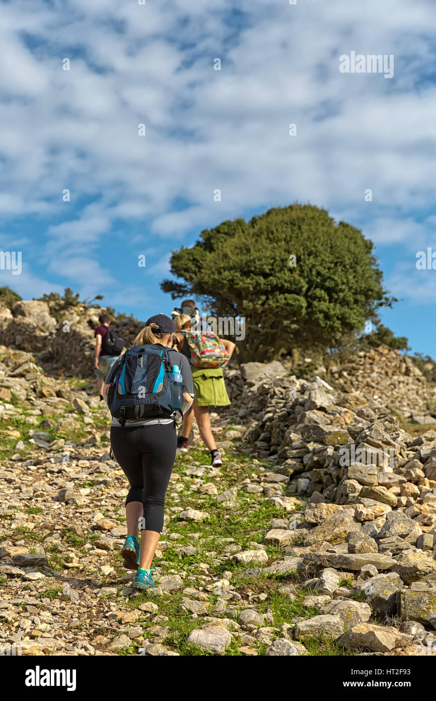 Frau in Gruppe Wandern, und bewundern Sie die wunderschöne Landschaft Blick auf die grünen Berge, Amorgos Island, Griechenland Stockfoto