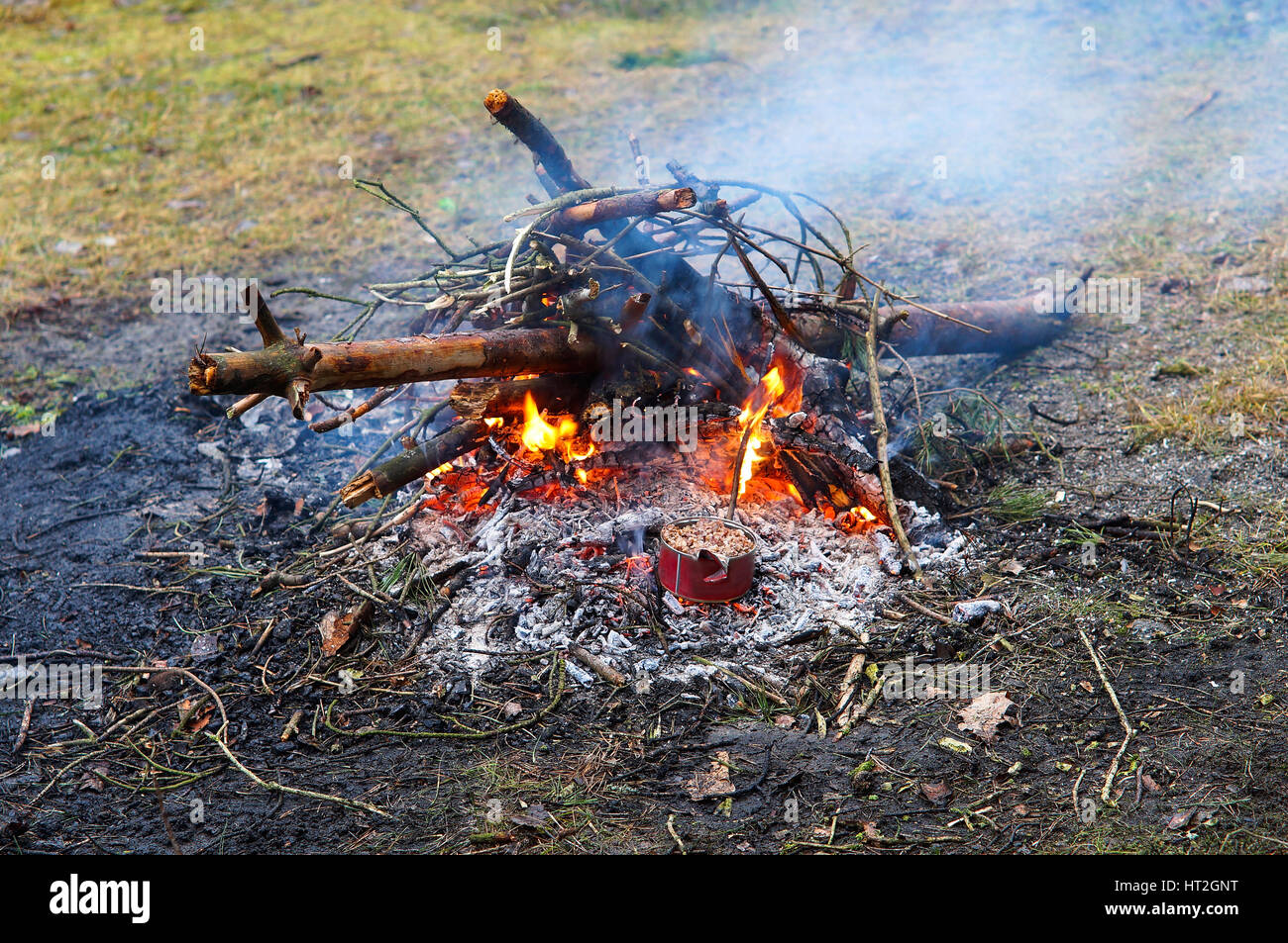 erwärmen Sie den Brei in der Dose am Lagerfeuer auf der camping-Ausflug Stockfoto