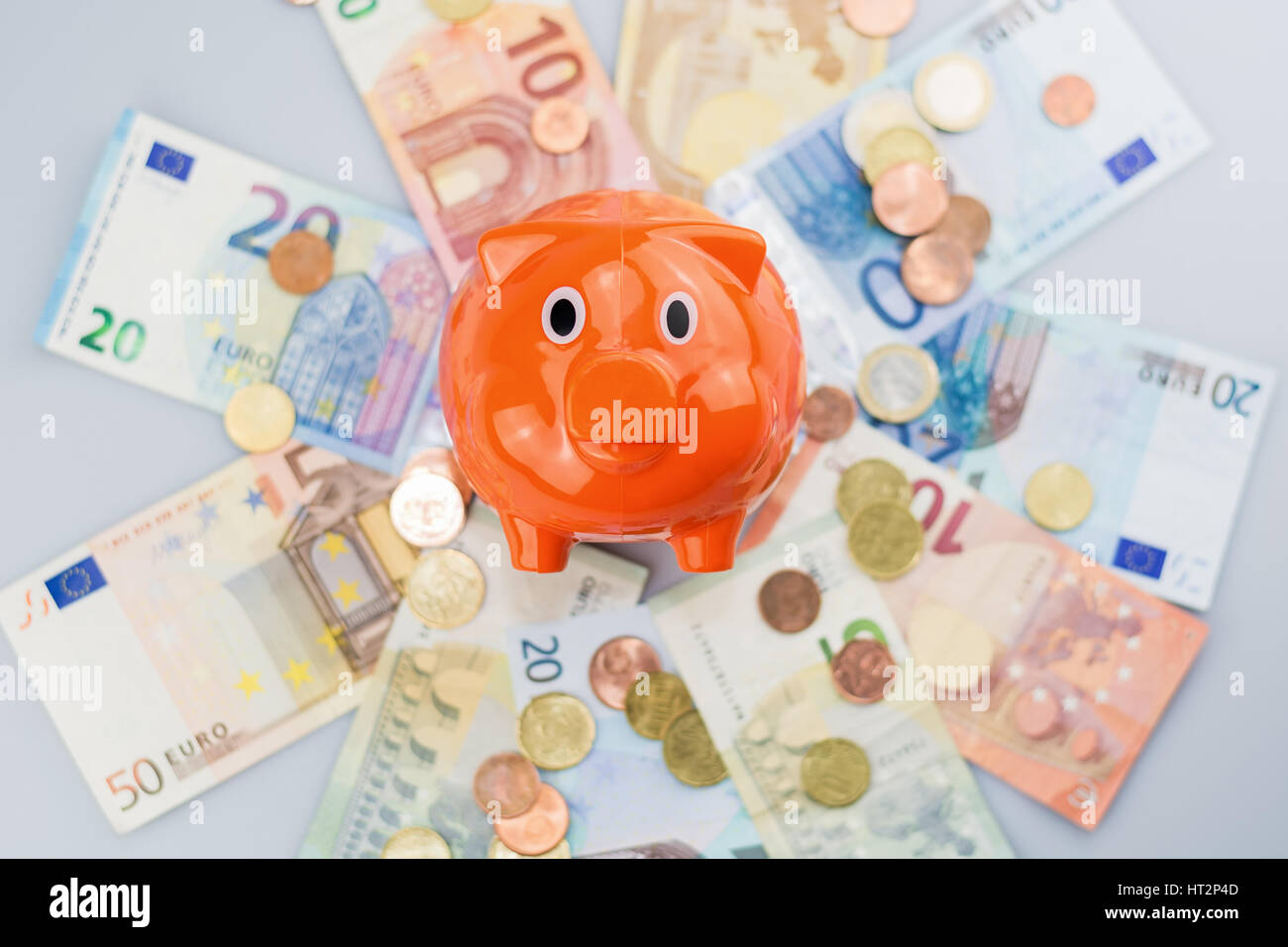 Piggy Bank beobachten einen Stapel von Euro-Banknoten und Münzen. Stockfoto