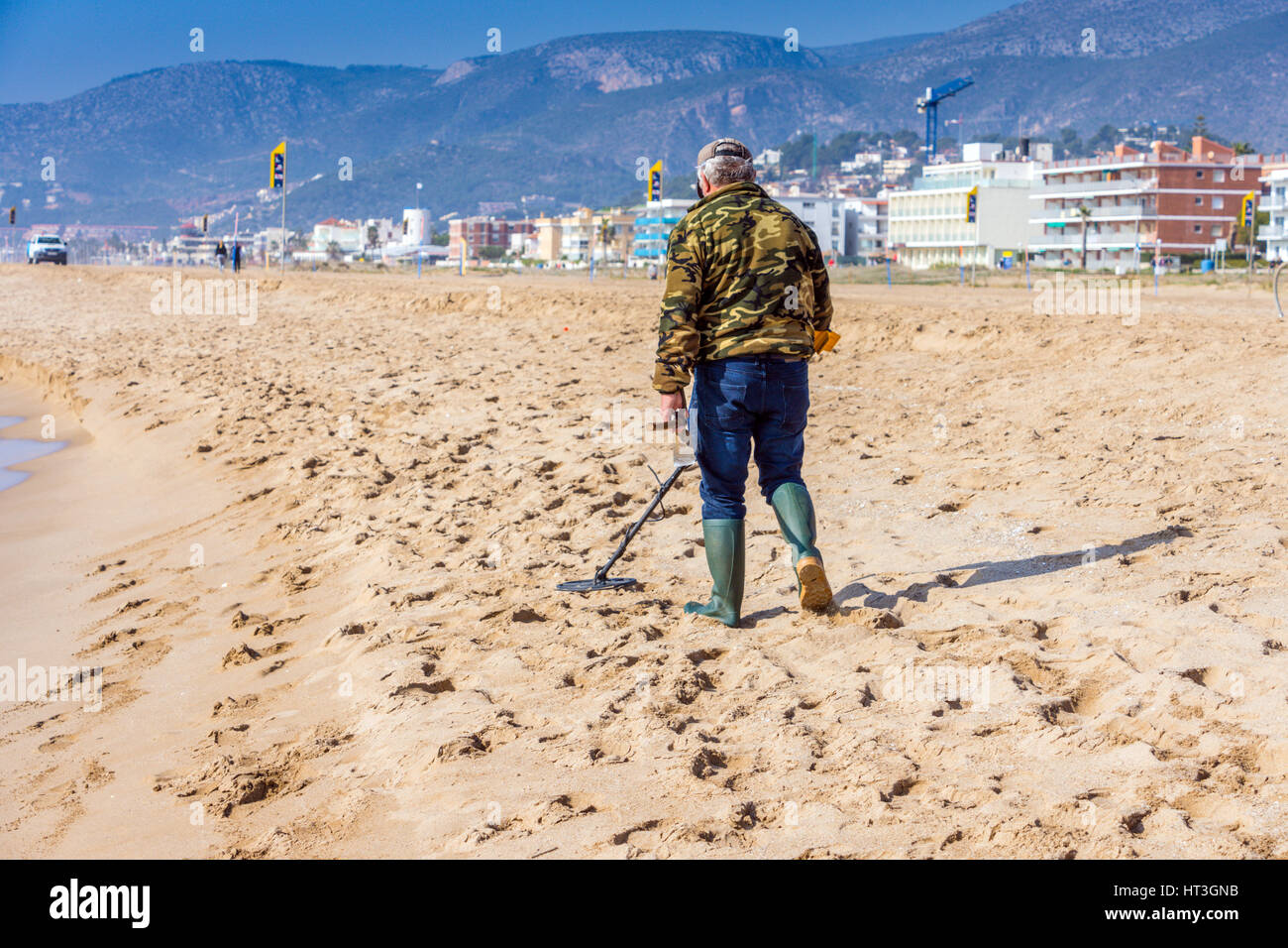 Mann mit Metalldetektor am Strand Stockfoto