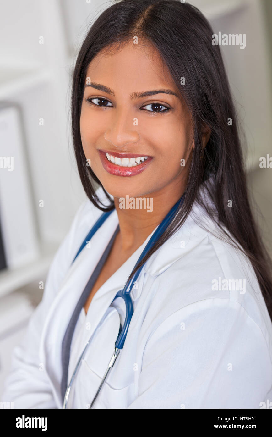 Eine indische asiatischen weiblichen Arzt in einem Krankenhaus Büro glücklich und lächelnd mit Stethoskop Stockfoto