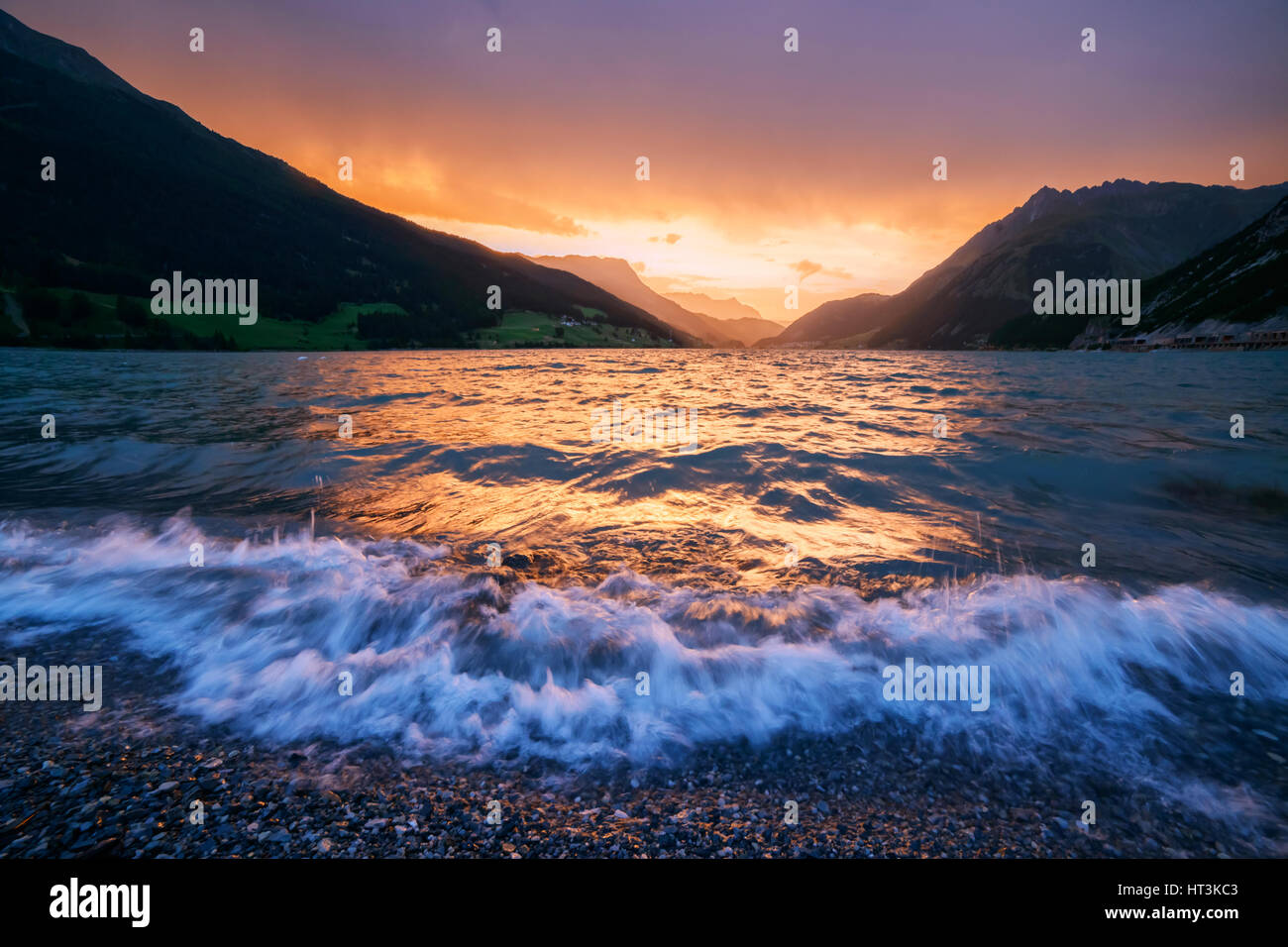 Schöne Aussicht auf den See Resia. Dramatischer Himmel und farbenprächtigen Sonnenuntergang. Alpen, Italien, Europa. Stockfoto