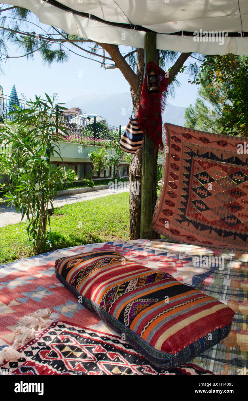Chillout Sitzbereich auf türkische Matten und Teppiche mit Sitzkissen  verstreut in der Mittagssonne türkische Stockfotografie - Alamy